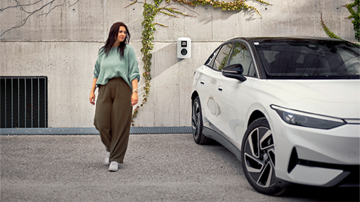 Žena jde vedle auta směrem ke kameře