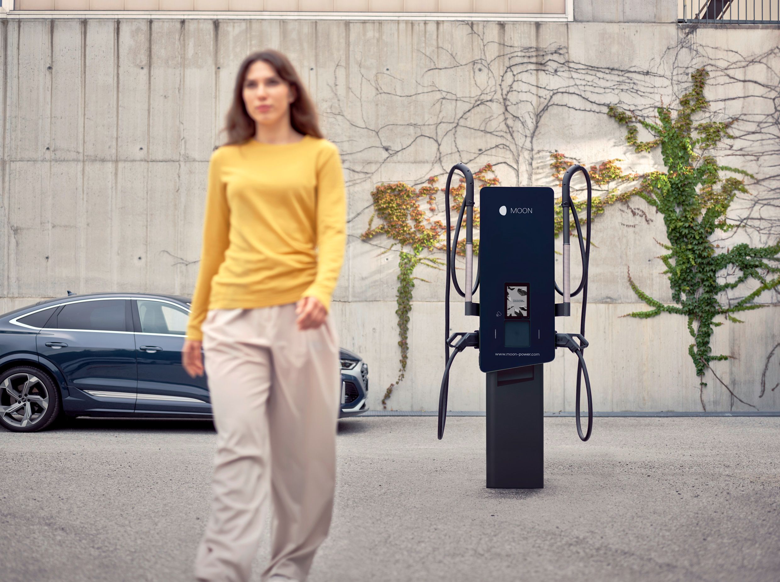 Žena odchází od nabíjecí stanice před autem