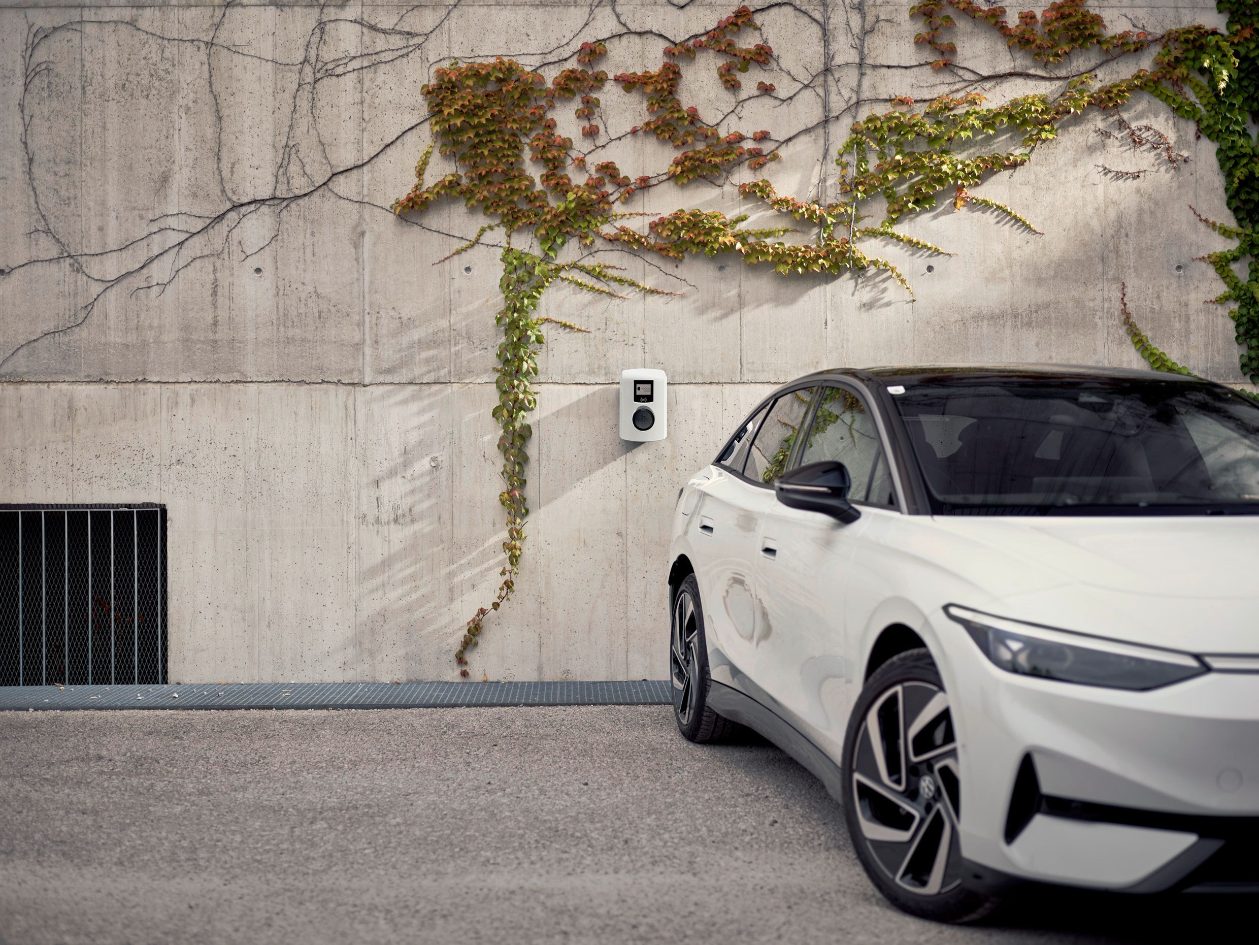 Auto stojí před betonovou zdí s nástěnnou schránkou