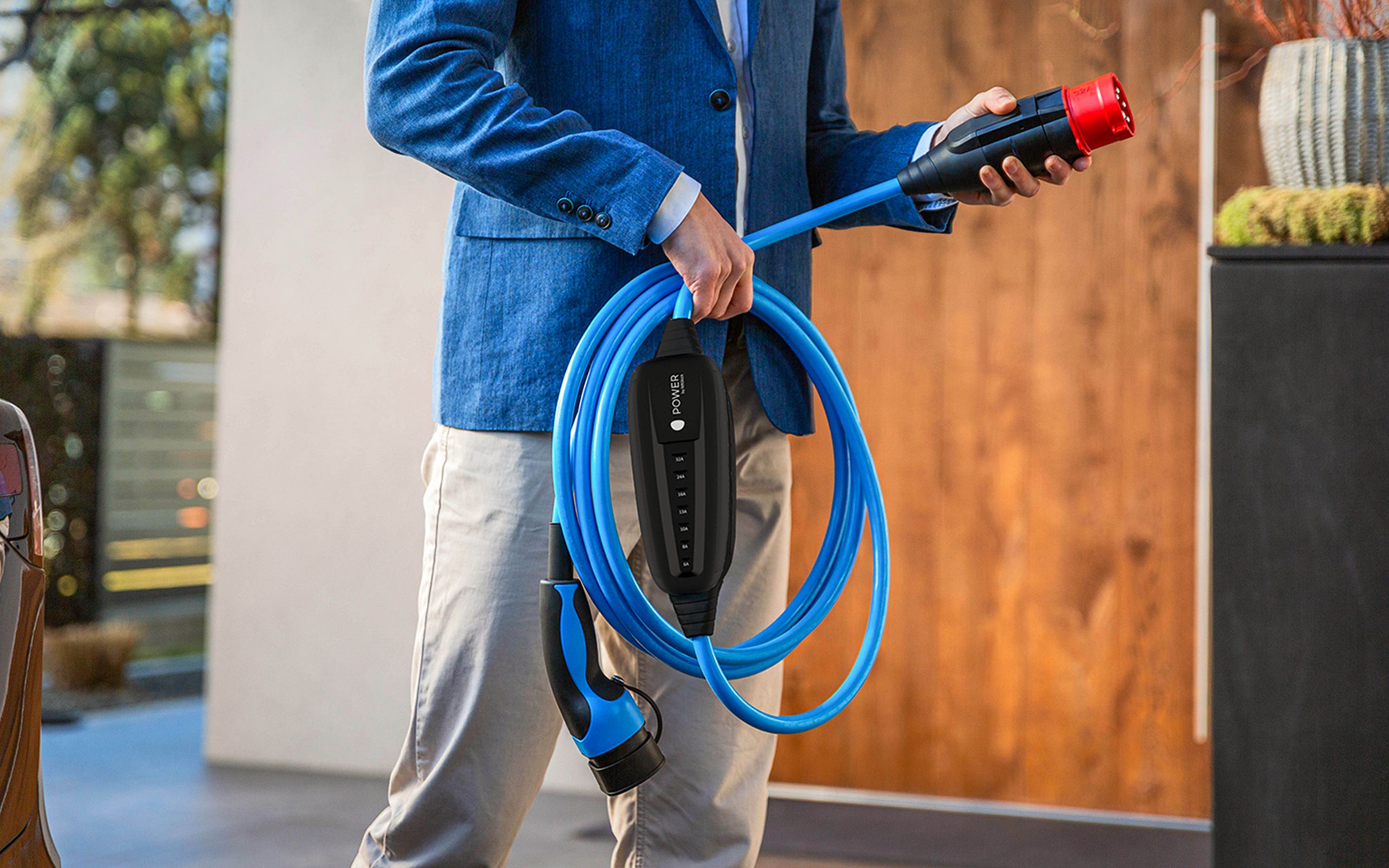 Muž drží v ruce zástrčku kabelu